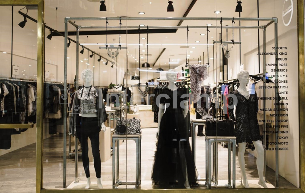 Retail store featuring garment racking and displays constructed with Interclamp tube clamps and fittings, blending modern industrial design with a high-gloss finish to complement the interior décor.